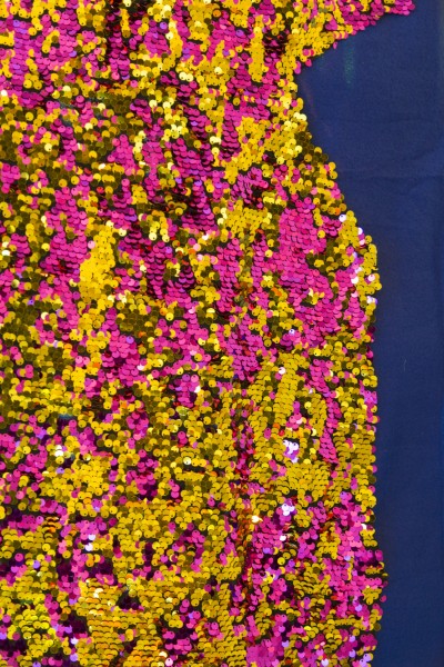 Close-up of the gold and violet sparkle fabric on top of blue fabric.