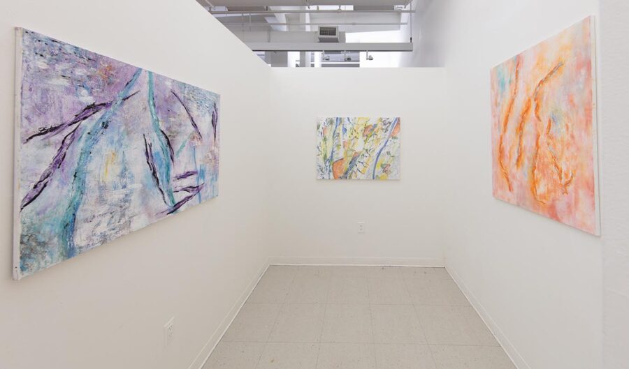 Installation shot of a room with three large scale paintings, one purple, one white, one orange.