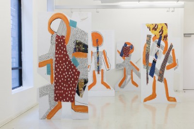 Installation view of large scale paintings with orange rounded and angled lines, and other colors like red, blue, and white and pieces of paper glued together