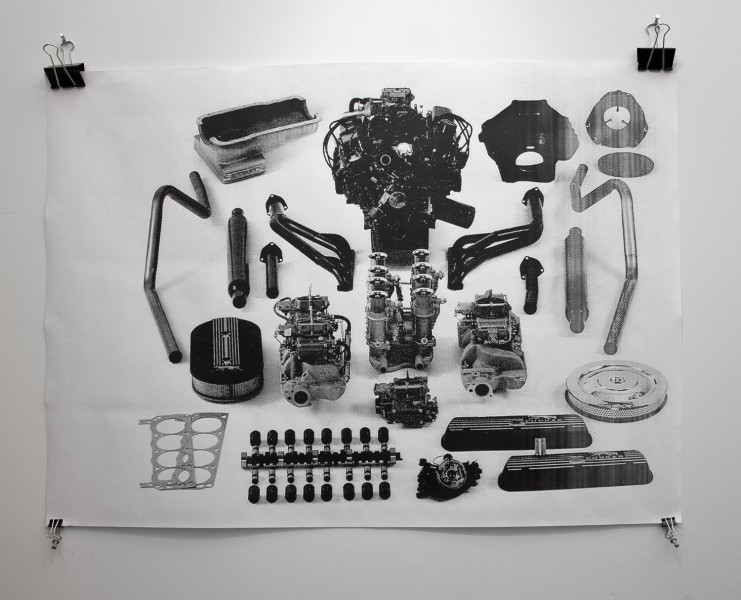 A whiteboard installed on the wall with paper clips illustrating car engine components.