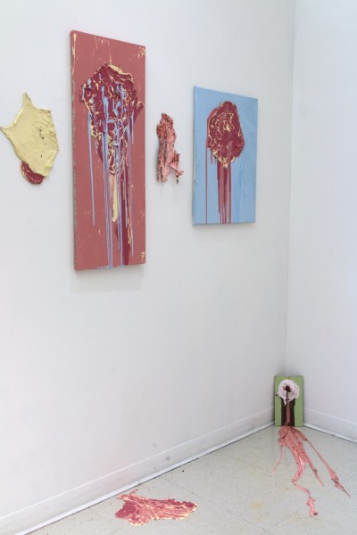 Two paintings on the wall, blue and pale red backgrounds, and various objects beside and on the floor.