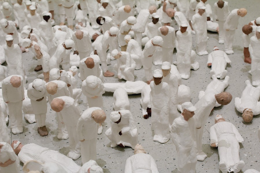 Small figurines of bowing people dressed in white.