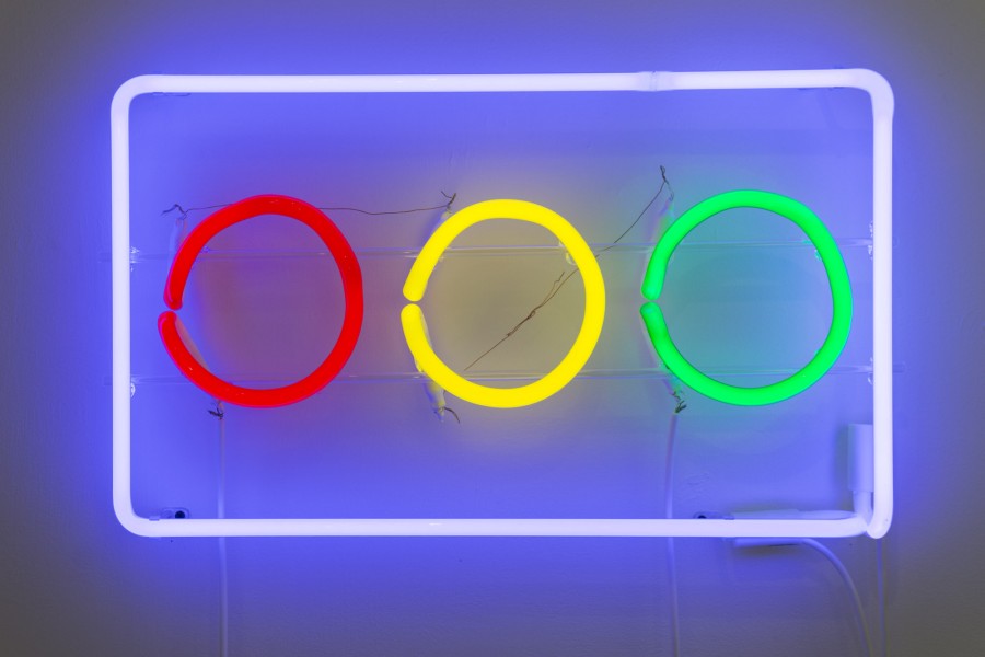 Three neon lights, red, yellow, and green boxed in a blue rectangle-shaped neon