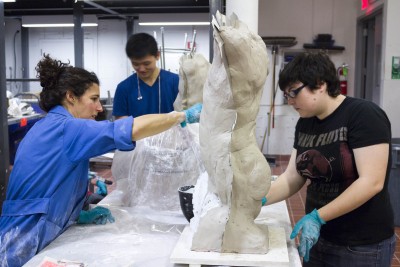 Two students working with a instructor for plaster Moldmaking