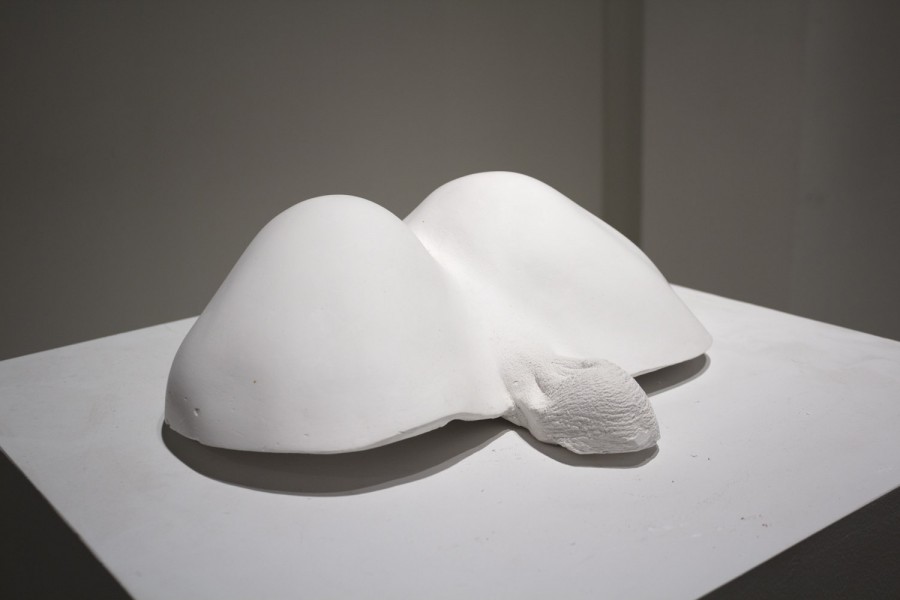Rounded body cast sculpture of a male bottom with the buttocks shape and a portion of the scrotum visible