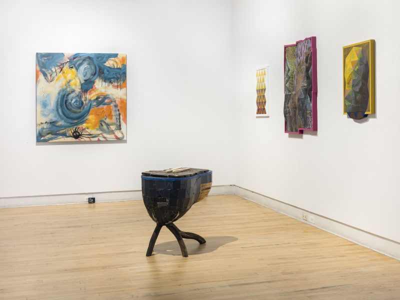 Install image of a gallery with four paintings on the wall and a sculpture on the floor