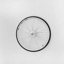 A rear bike wheel installed on a white wall