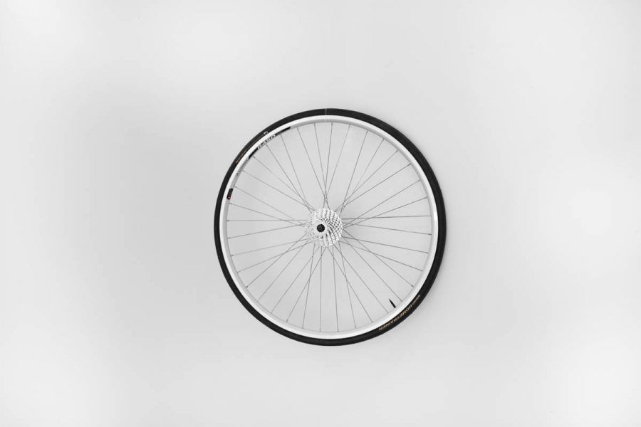A rear bike wheel installed on a white wall