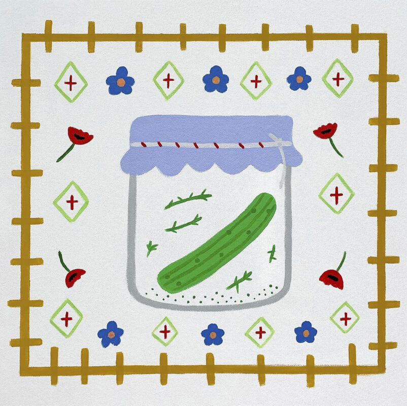 One green fermented pickle in a jar. Surrounding is poppy flowers, textile print, and blue flowers.