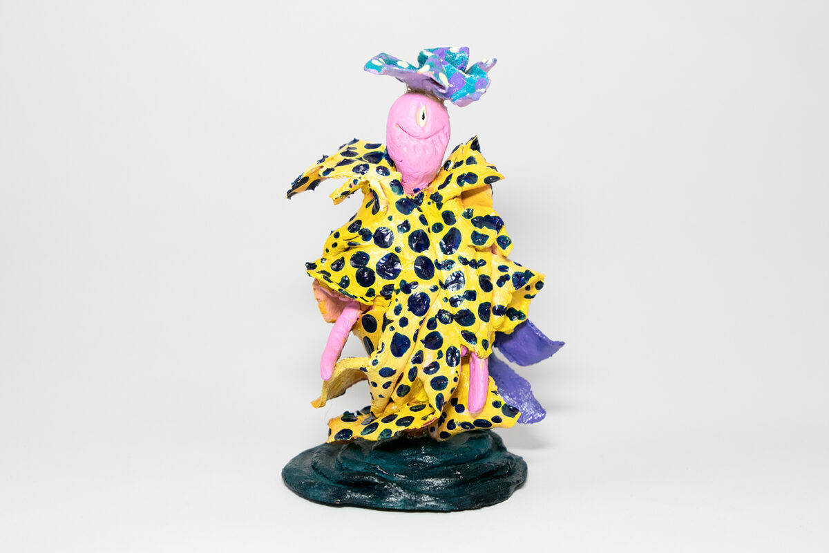 A small figurative ceramic sculpture painted in bold colors and patterns.