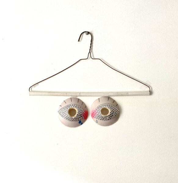 Reworked bra padding, embellished with rhinestones and paint to create a representation of eyeballs.