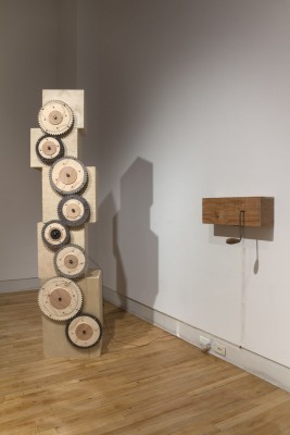 A tower made of cubes and cogs is installed, a woodblock, and a crack on the near wall.