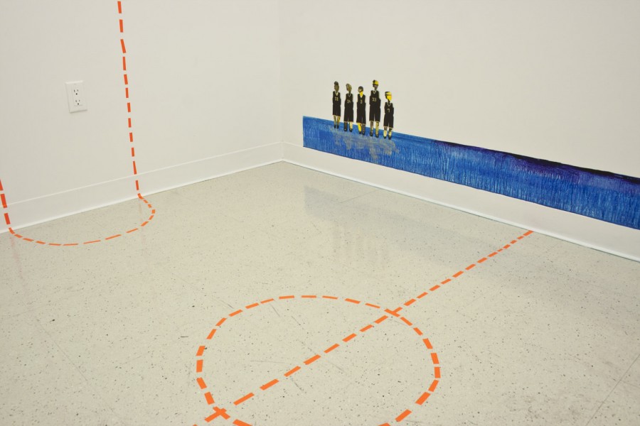 Exhibition view of a small sports field made with neon orange tape on the floor and the wall, a thick and long blue stripe of blue paint like water with five human figures and their reflection on the water.