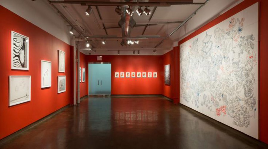 Exhibition view of abstract paintings installed on red walls
