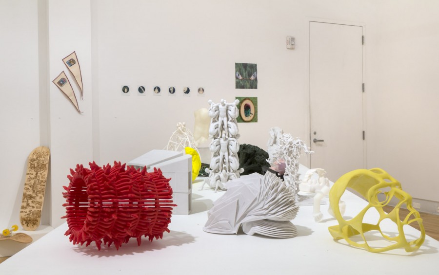 Organically shaped sculptures made of red, white, and yellow materials, with organic rounded and curved shapes, installed on a white table