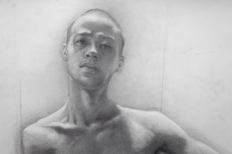 A drawing of a male model from the BFA Fine Arts drawing class. The drawing features the model from the shoulders up. The drawing of the model is facing forward with the gaze staring off to the side.