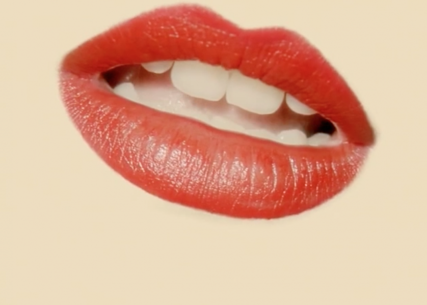 An open mouth with red lips with front teeth visible, on a light beige background