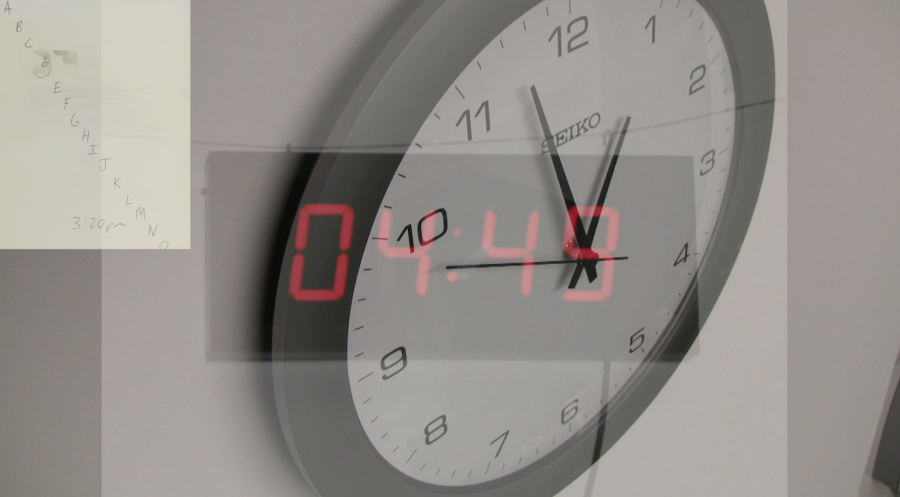 A digital clock photograph overlayed on an analog clock on a wall.