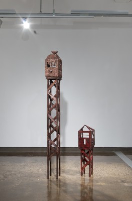 A tall wooden tower and a smaller wooden tower are painted in maroon.