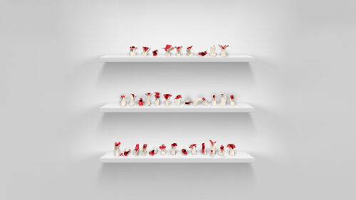 Three shelves are installed on a wall with several ceramic mushrooms placed randomly between the three shelves. The mushrooms have an off-white stem with a red top.