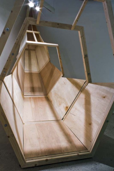 Wood sculpture made of wood boards, wood pieces, in the shape of a slide without top cover