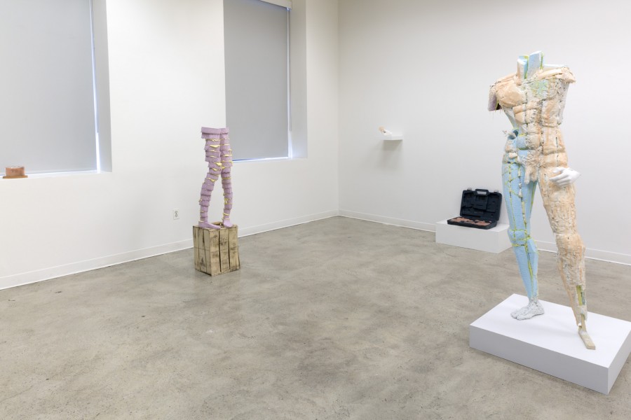 Installation view of an anthropomorphic sculpture represents a body without hands and head, and another sculpture represents the lower part of the body with the feet.