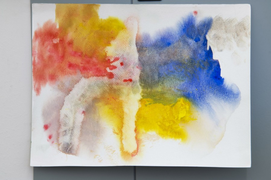 abstract painting made with splashes of watercolors on a white paper with colors like red, yellow, and blue