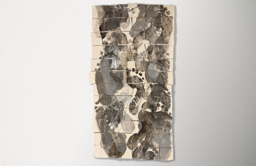 Ceramic with tile like shapes that are stacked vertically, foot prints images are pressed on the surface