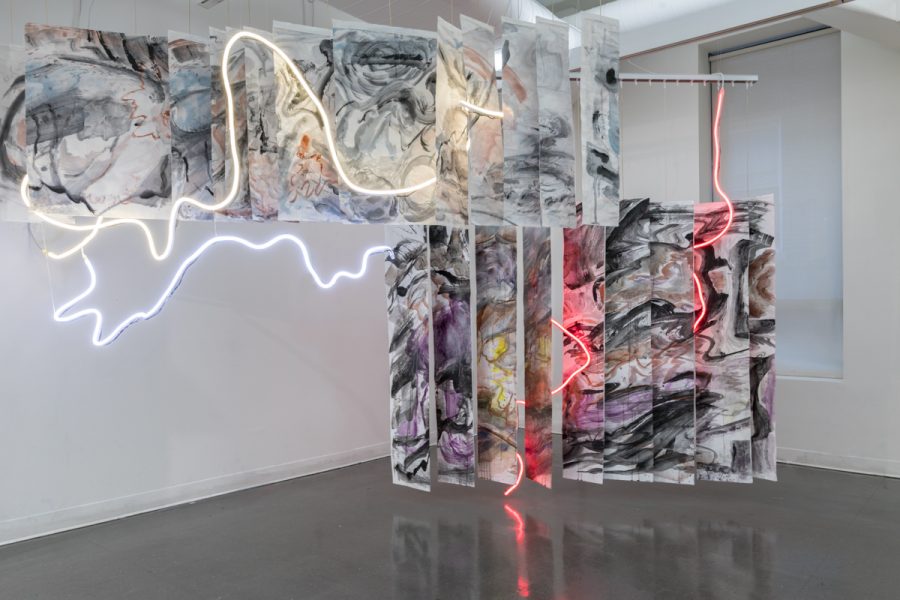 Installation view of artwork by Yesiyu Zhao. Chromatic mixed media artwork with abstract brush strokes, torn fabric interwoven with neon lights.