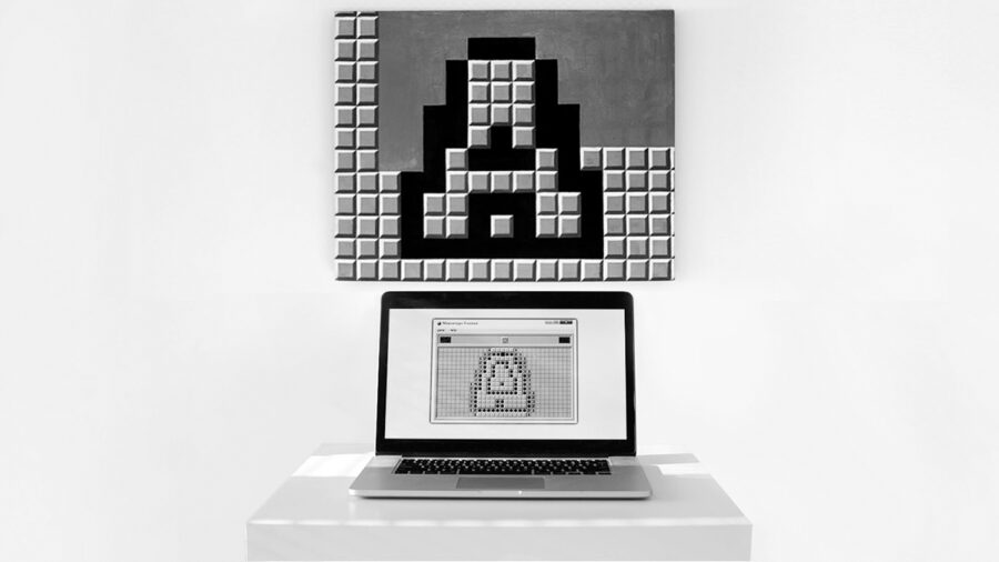 A picture of a laptop computer open on a pedestal. On the computer screen and behind it on the wall is a low-res computer graphic image referencing Duchamp's Fountain.