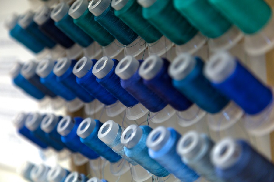 Close-up of sewing threads colored in different shades of blue