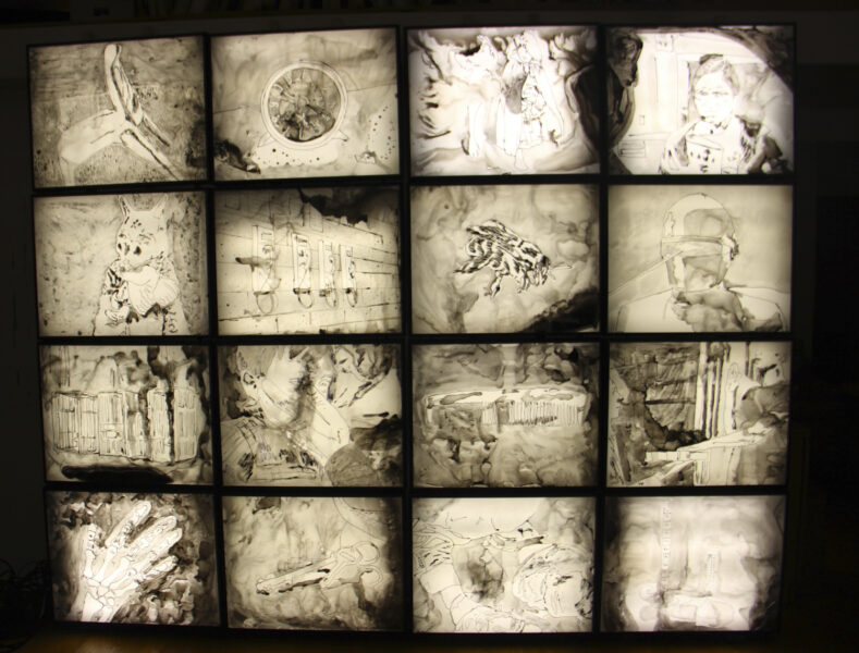 A four-by-four grade of ink drawings on mylar, mounted on light boxes.
