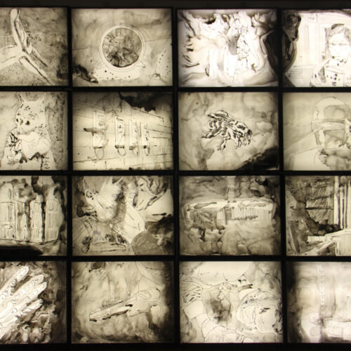 A four-by-four grade of ink drawings on mylar, mounted on light boxes.