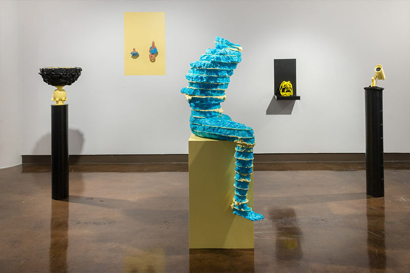 Installation view of anthropomorphic sculpture made of blue material.