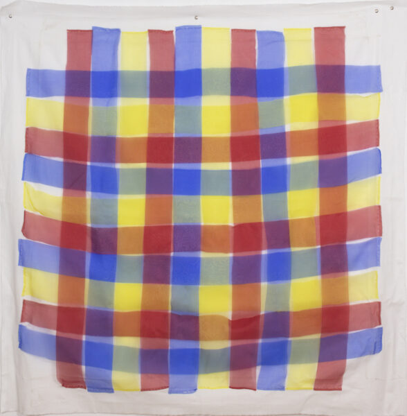 A grid made of woven strips of yellow, red, and blue silk on white muslin.
