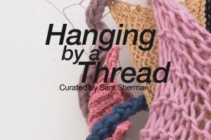 A poster advertisement for the exhibition, "Hanging by a Thread" at the SVA Chelsea Gallery. The poster shows the exhibition title and reception information in black text. In the background is the detail of a sculpture by Carlin Phillips. The sculpture is made up of different colored threads that have been weaved together.