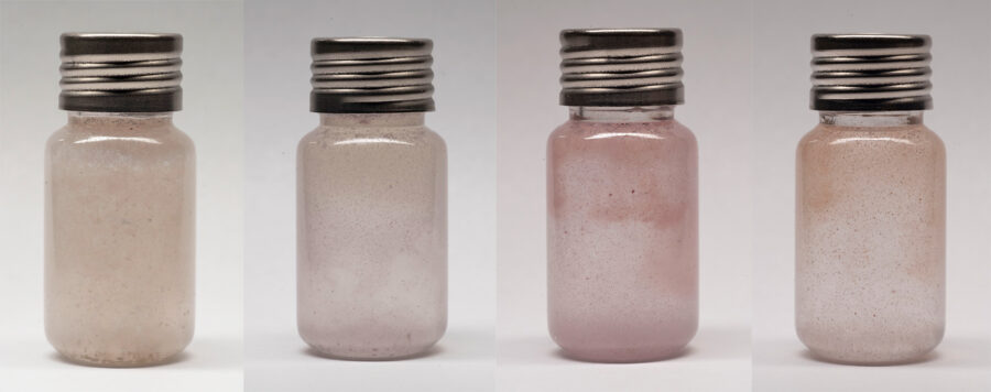 Photo still of a glass vial, pigment is floating and swirling inside