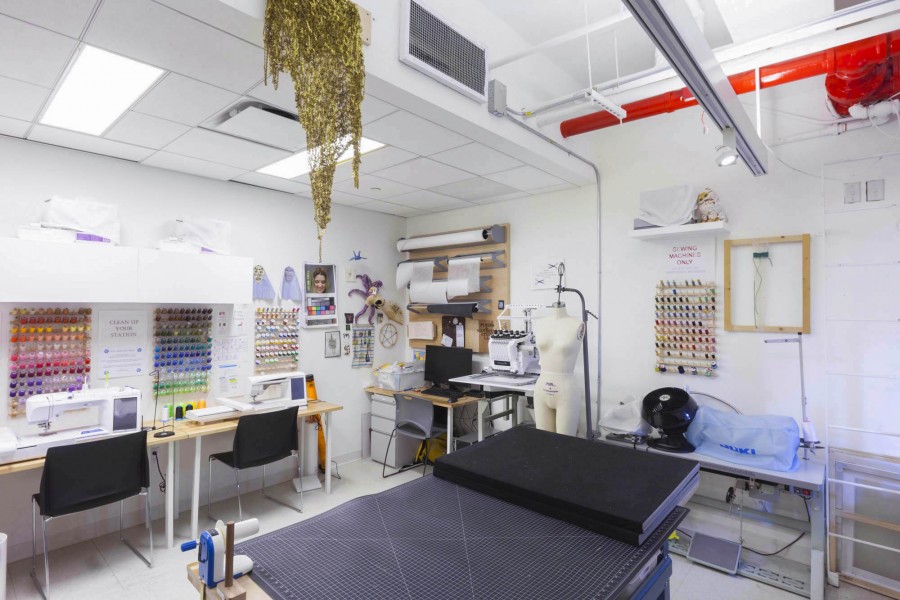 Overview of the Fiber lab with sewing yarn, threading tools, precision table, mannequin, and sewing machine